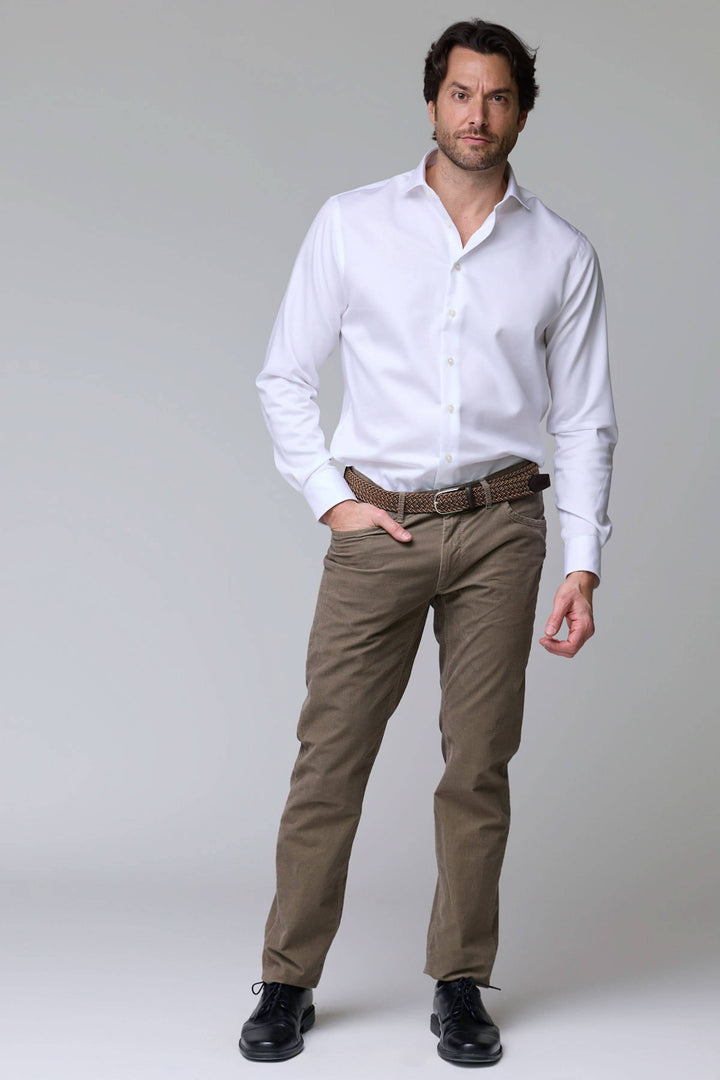 Homme portant un pantalon cinq poches en velours côtelé avec chemise blanche, idéal pour bureau ou sorties décontractées.