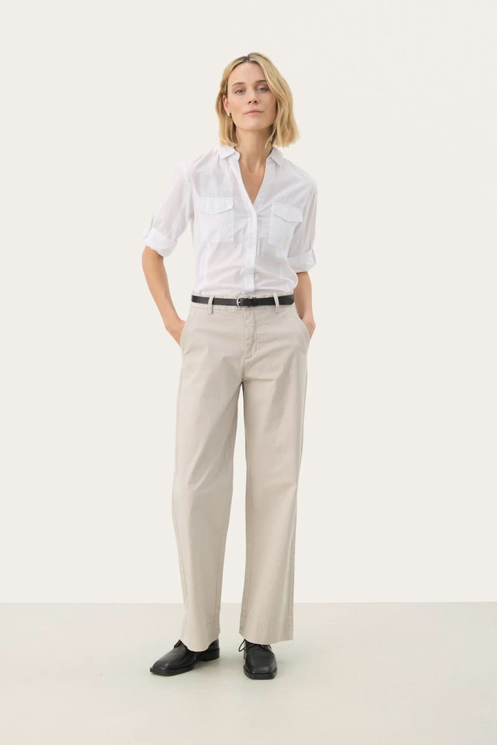 Modèle portant un pantalon à coupe droite en coton et élasthanne, élégant et confortable, idéal pour le bureau ou sorties décontractées.