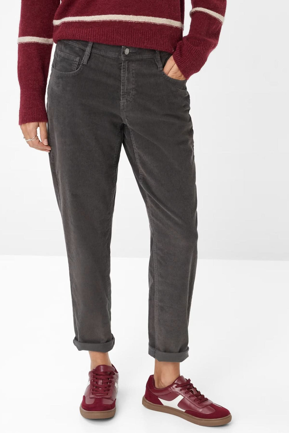 Pantalon de style Mary en gris foncé, coupe décontractée, porté avec un pull rouge et des baskets assorties.