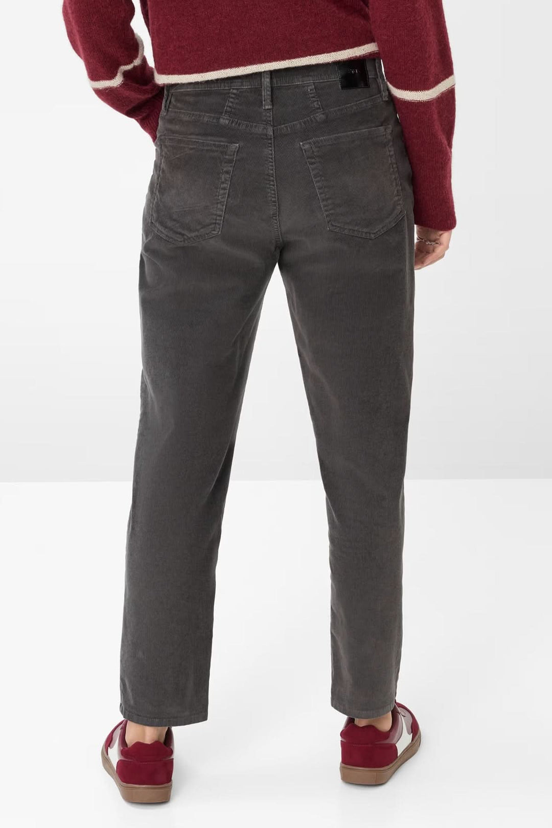 Pantalon Mary à coupe décontractée gris foncé avec taille mi-haute et jambes fuselées, porté avec un pull et des baskets.