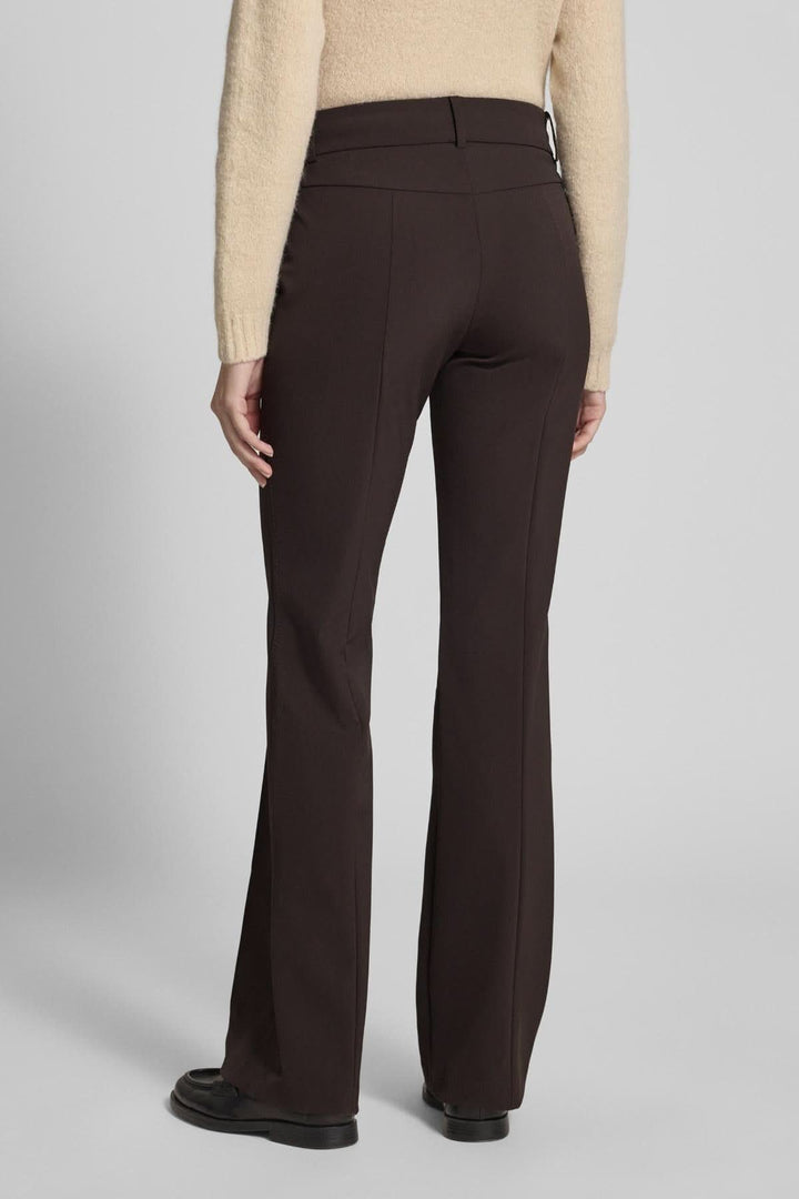 Vue arrière du pantalon droit évasé à plis marqués, coupe élégante et taille mi-haute, porté avec un chandail beige et des chaussures noires.