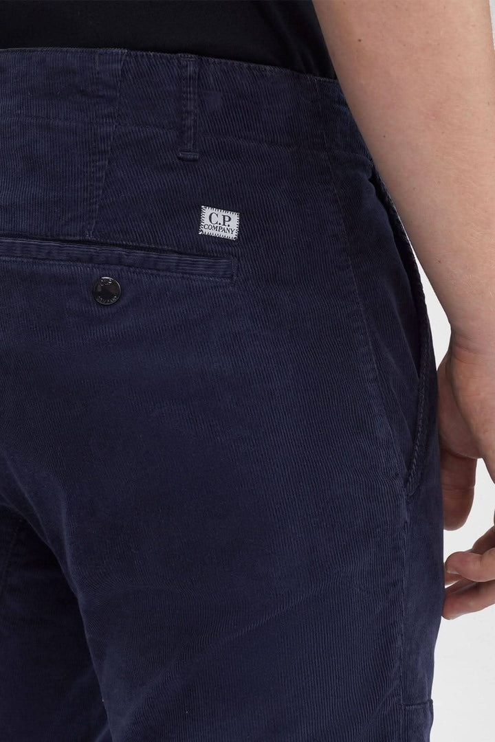 Pantalon en corduroy C.P. Company avec braguette zippée et poches arrière, couleur bleu marine.