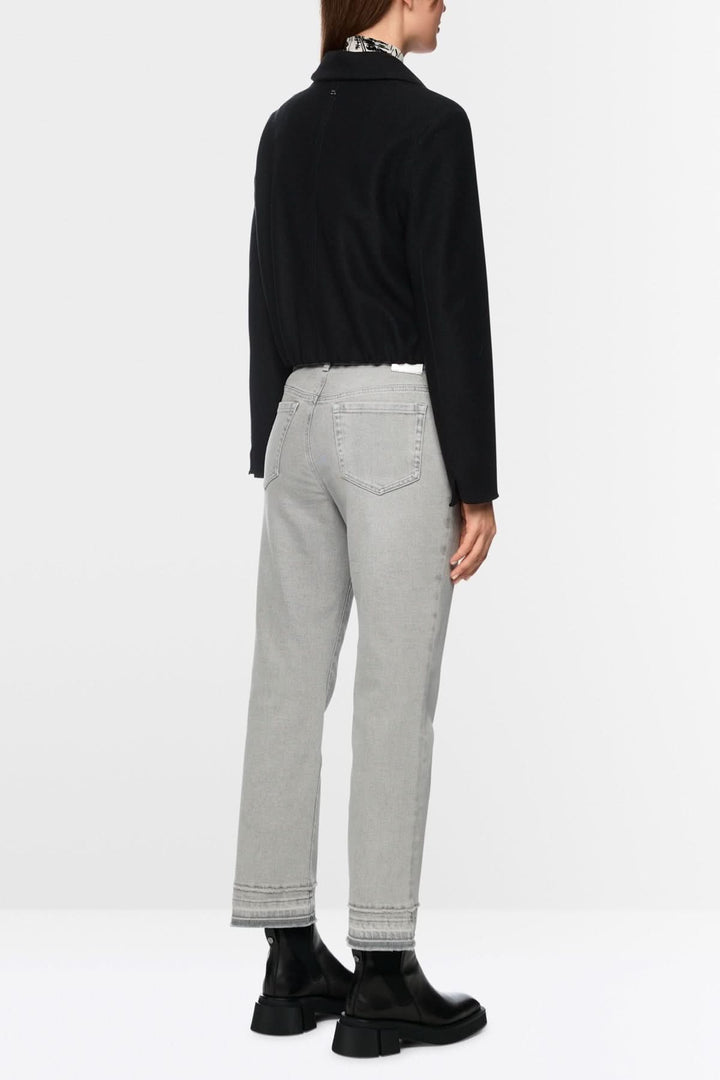 Pantalon en denim à coupe droite, légèrement évasée, avec effet effiloché au bas, style moderne et décontracté, vue arrière.