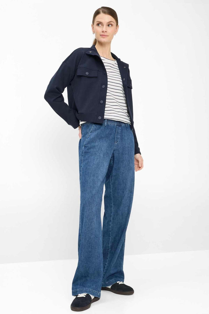 Femme portant un pantalon en denim MAINE à jambe large avec veste et t-shirt rayé pour un look casual chic.