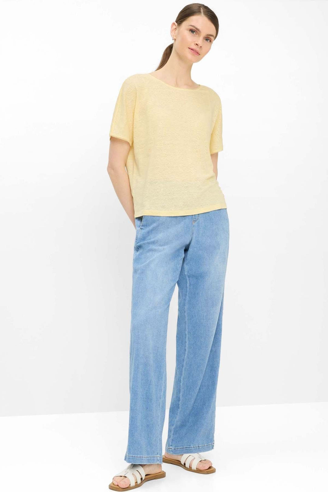 Femme portant le pantalon en denim MAINE à jambe large avec t-shirt jaune, illustrant un style casual chic moderne et confortable.