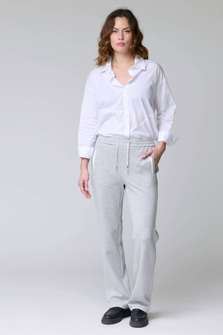 Femme portant un pantalon en jersey ajustable gris avec taille élastique, cordon et poches, idéal pour un style décontracté et confortable.