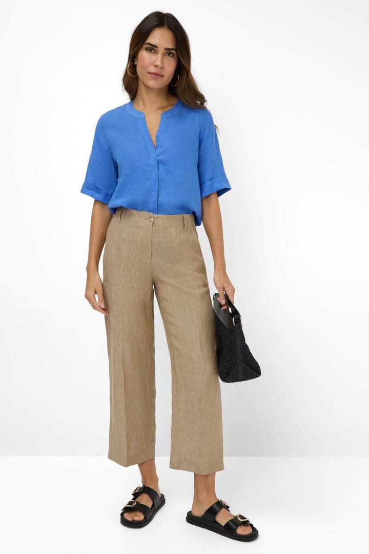 Femme portant pantalon en lin MAINE S à jambes larges avec chemisier bleu, ajoutant une touche élégante à son look.