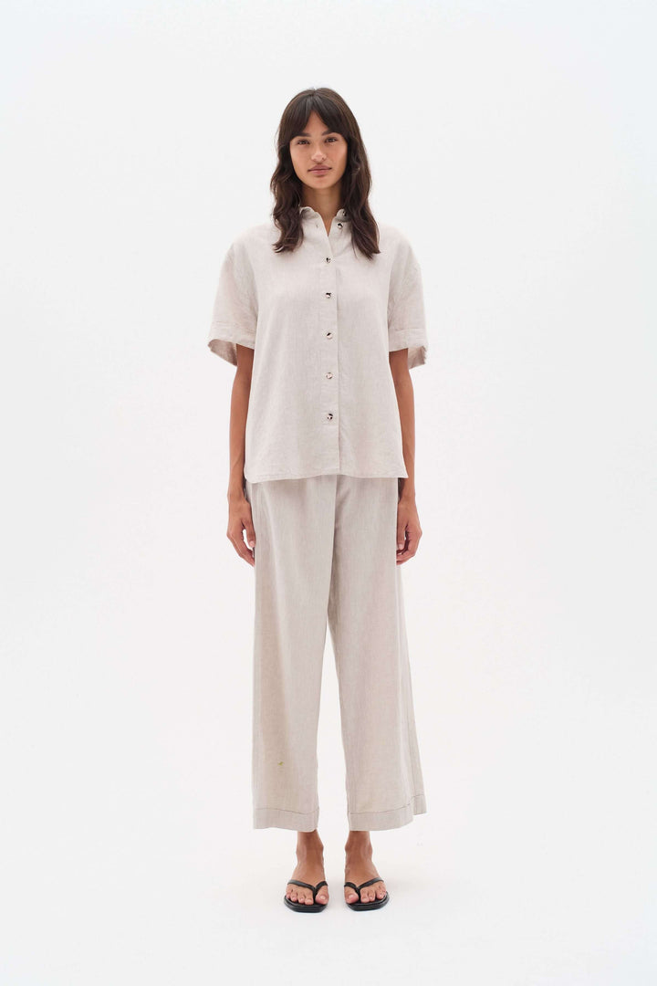 Femme portant un pantalon en lin Rimona Driza, avec taille élastique et jambes larges, style confortable et élégant.