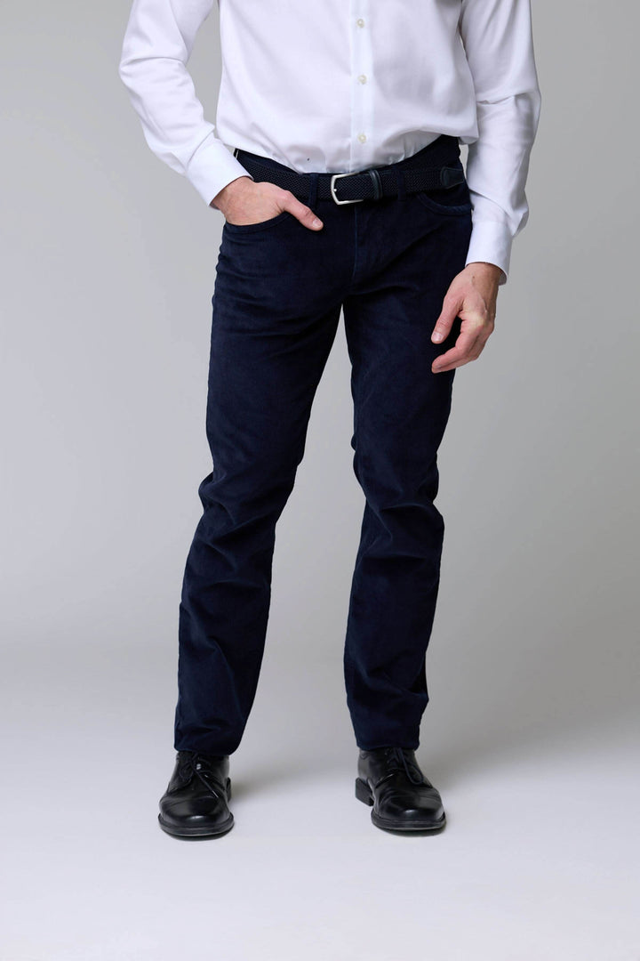 Homme portant un pantalon en velours côtelé bleu, coupe droite, avec chaussures noires, pour un look élégant et décontracté.