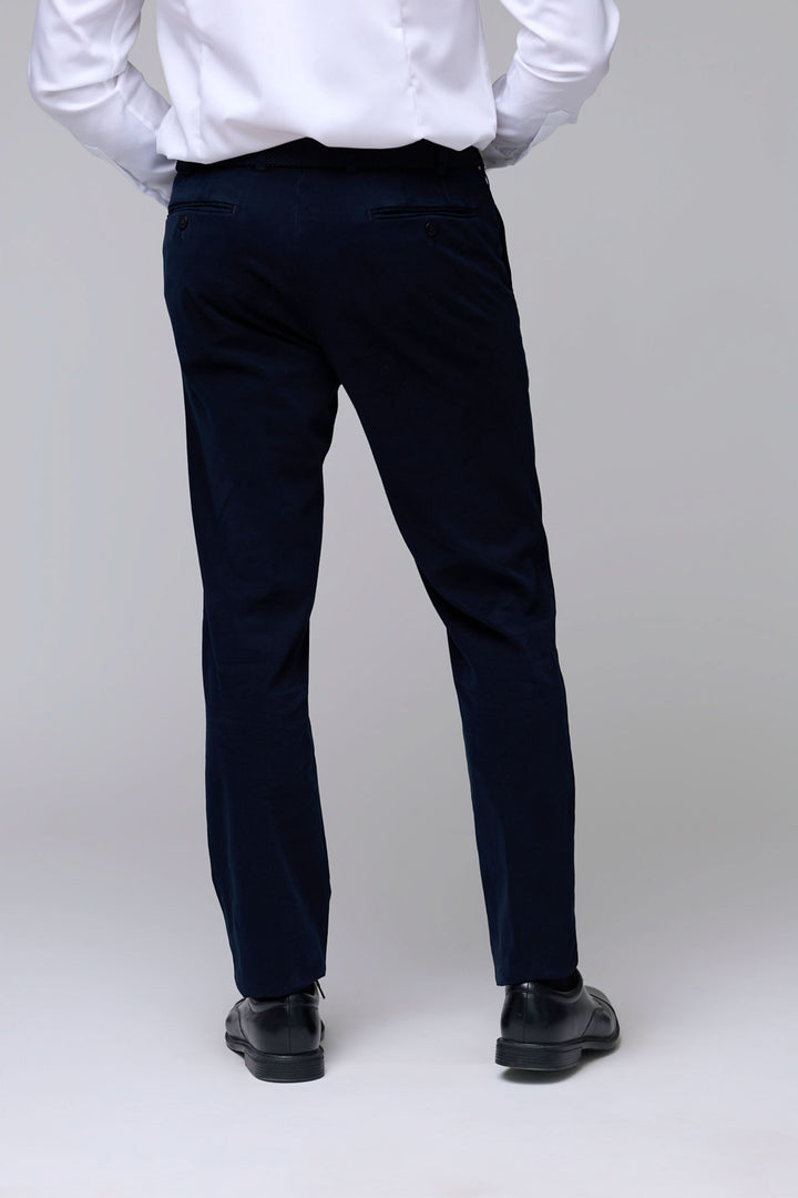Homme portant un Pantalon en velours côtelé fin bleu marine avec coupe ajustée et cinq poches, élégant et confortable pour le quotidien.