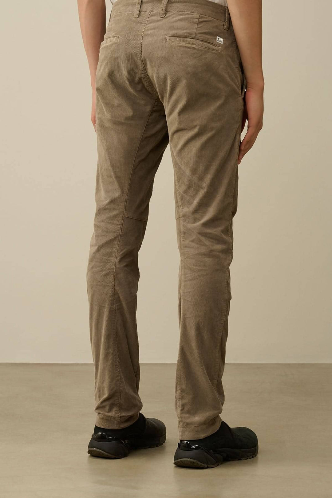 Pantalon ergonomique en velours côtelé, vue arrière, couleur beige, avec poches et coupe ajustée.