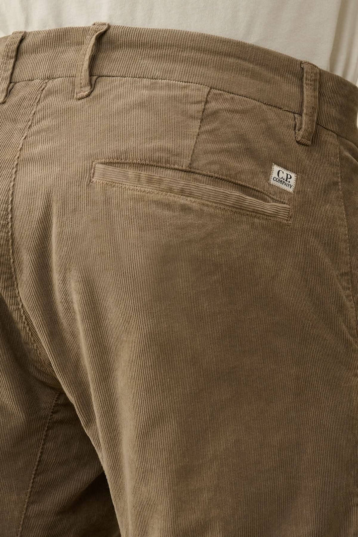 Détails du pantalon en velours côtelé avec poche arrière et écusson griffé CP.