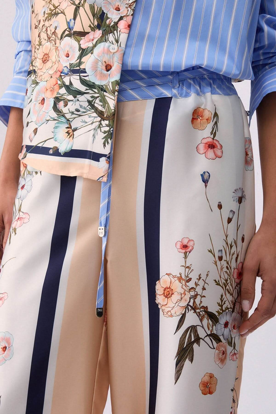 Pantalon fluide à motifs et rayures contrastées avec fleurs et rayures, vue rapprochée du design élégant et moderne.