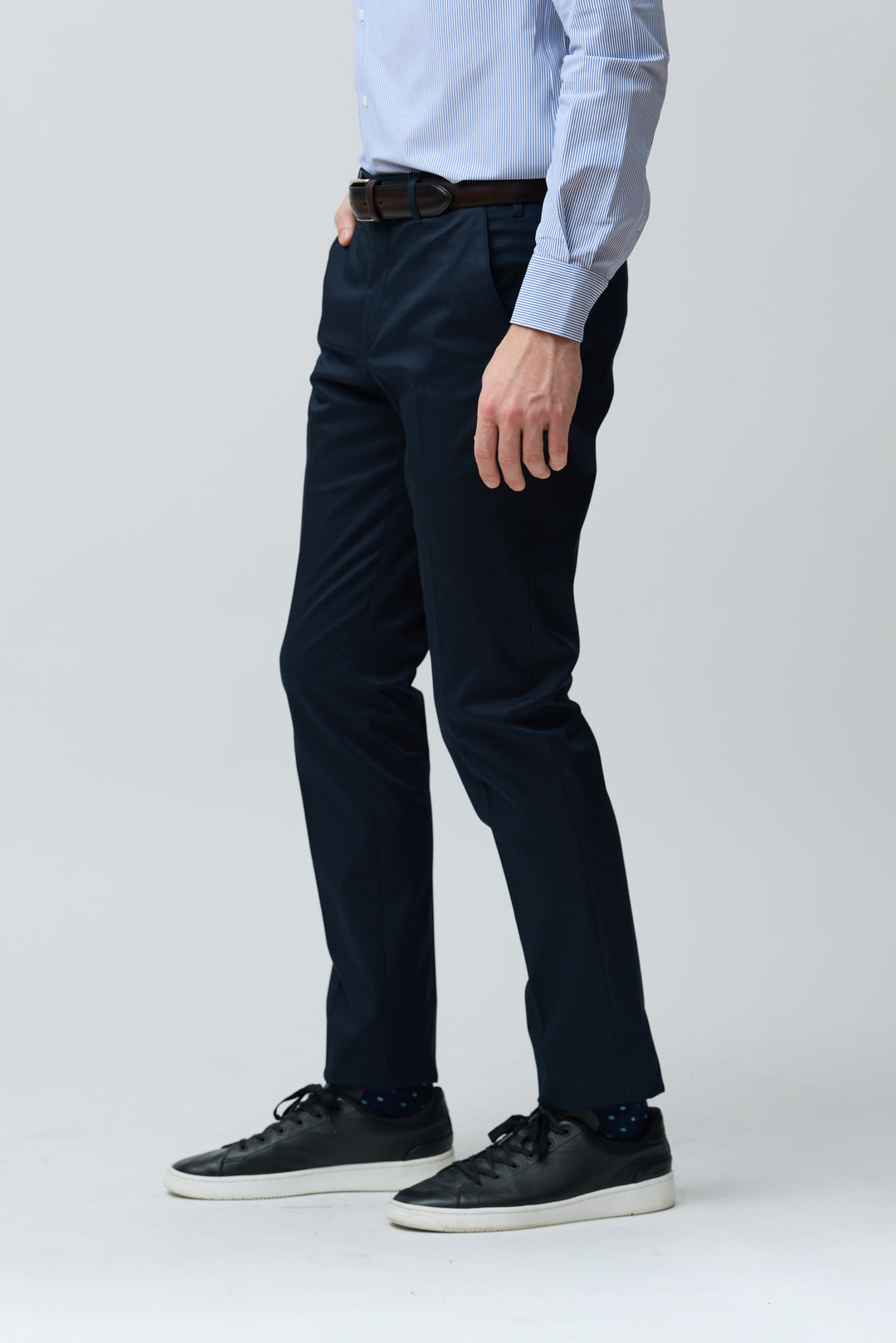 Homme portant un pantalon habillé coupe ajustée bleu marine avec ceinture, ajusté et élégant.
