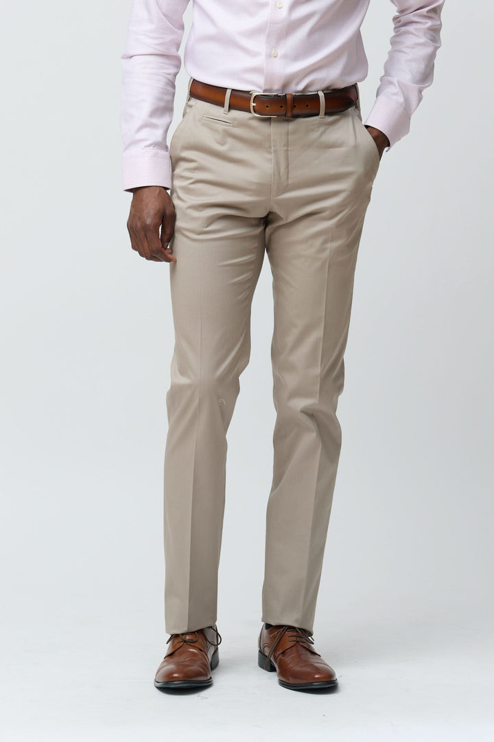 Homme portant un pantalon habillé coupe ajustée beige, idéal pour un look professionnel ou décontracté.