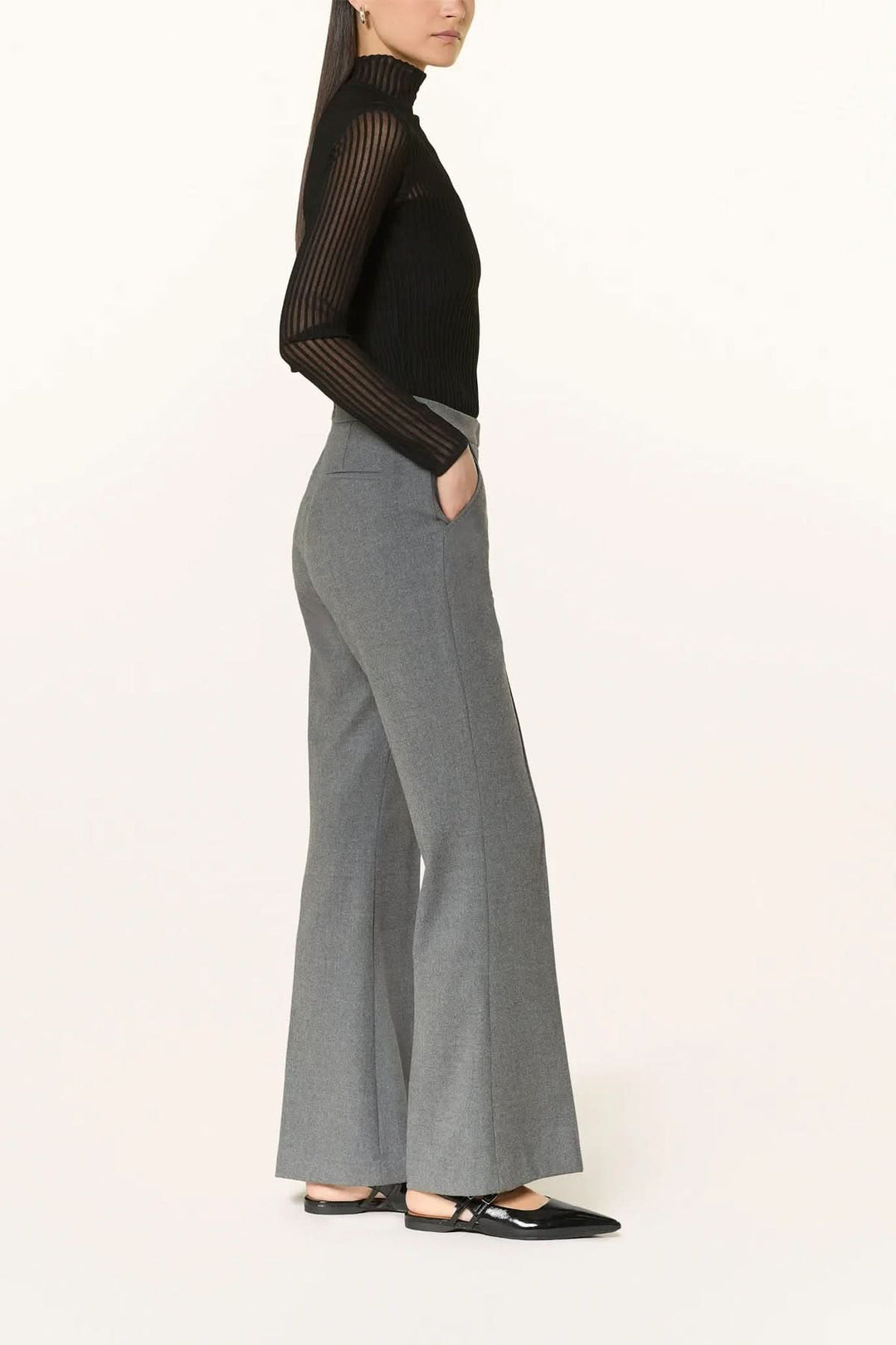 Pantalon habillé coupe évasée à plis marqués avec taille lisse, porté par modèle, vue de côté, stylish office attire.