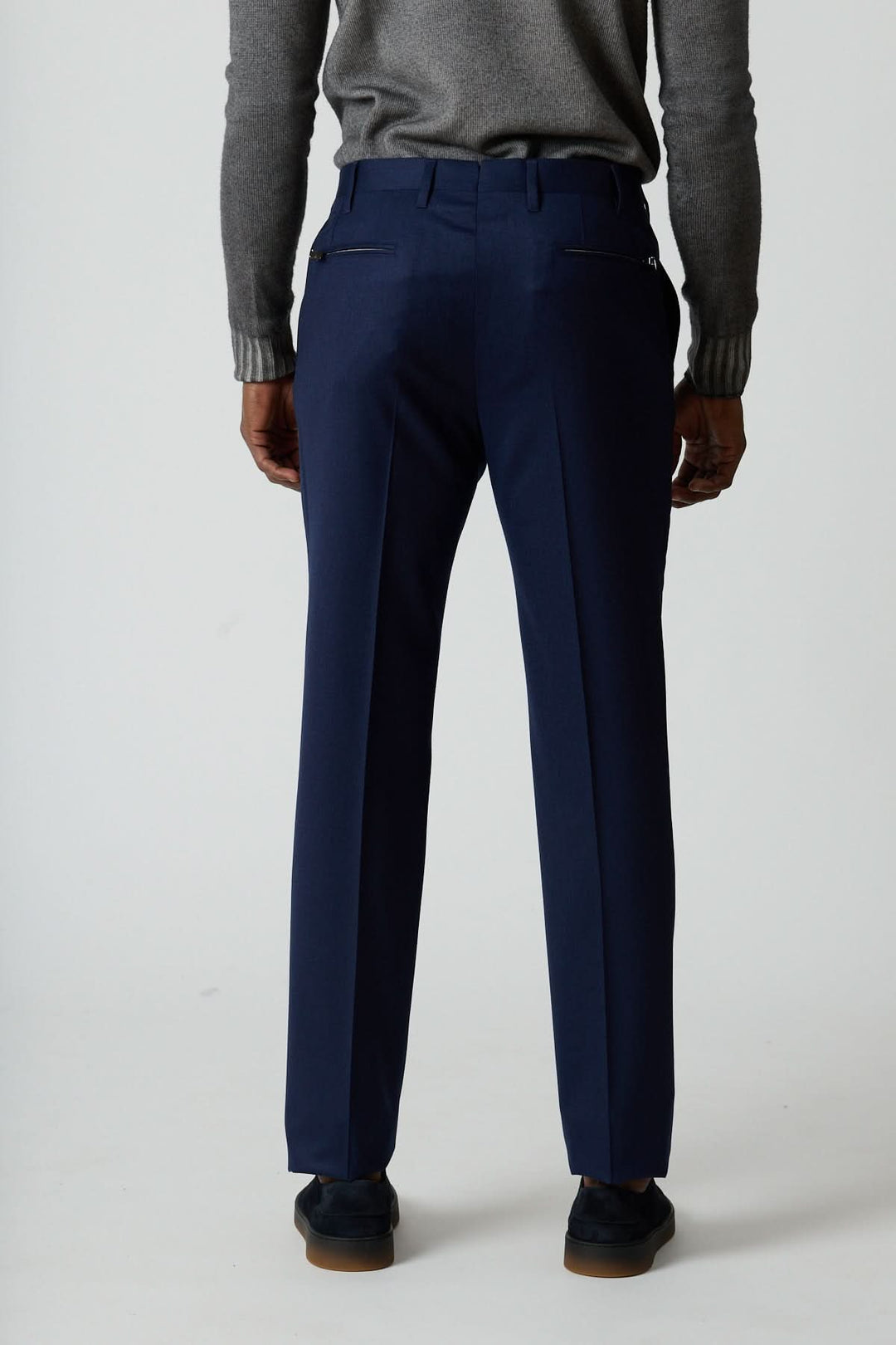 Vue arrière du pantalon habillé en laine vierge Corneliani bleu avec poches zippées et coupe élégante.