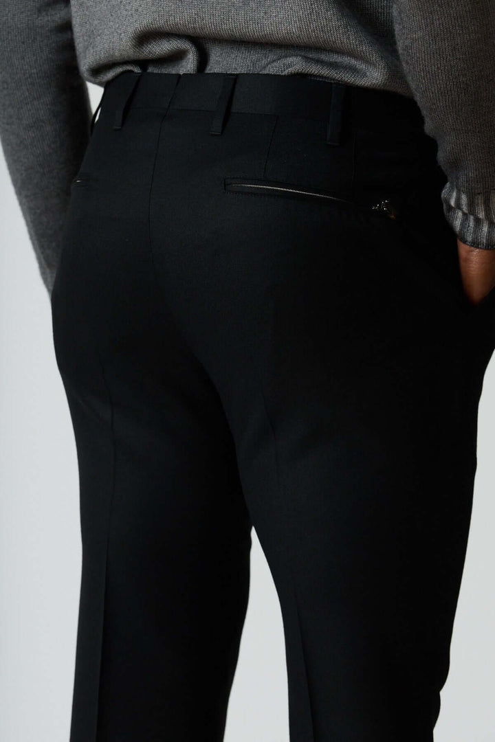 Pantalon habillé en laine vierge noir avec poches arrière zippées et coupe élégante pour un style professionnel moderne.