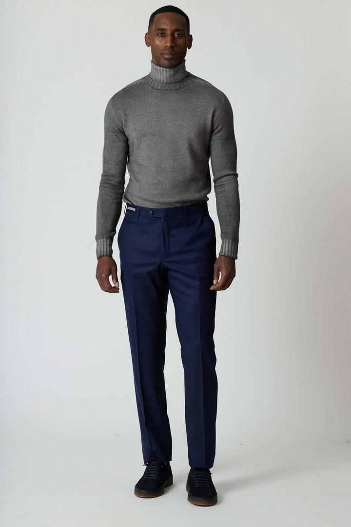 Homme portant un pantalon habillé en laine vierge Corneliani, coupe élégante avec poches zippées, style professionnel et moderne.