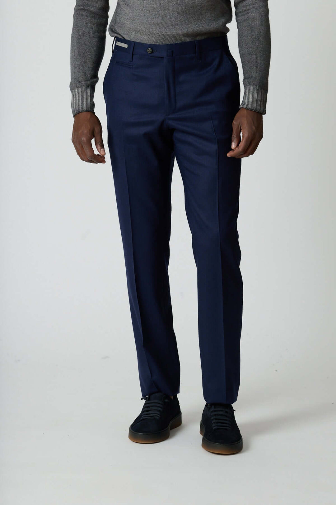 Homme portant un pantalon habillé en laine vierge bleue avec poches arrière zippées et coupe élégante à pli marqué