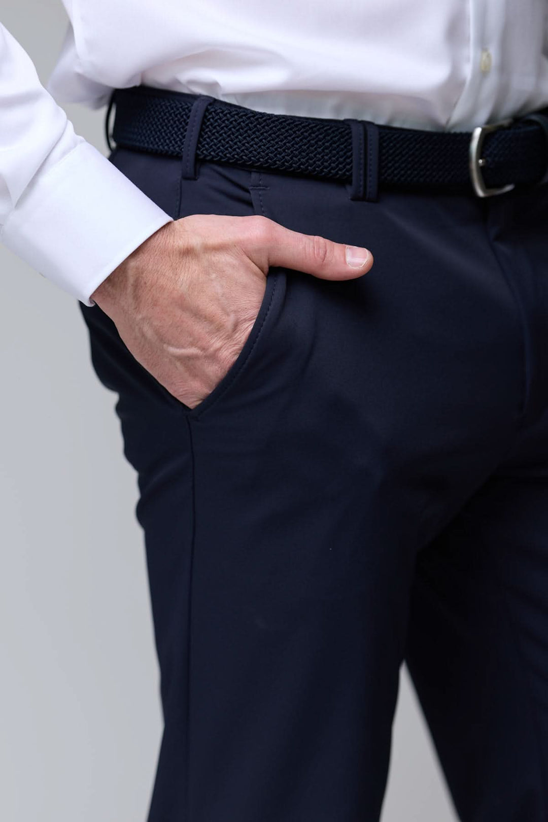 Homme portant pantalon habillé extensible noir, coupe droite, avec chemise blanche et ceinture noire.