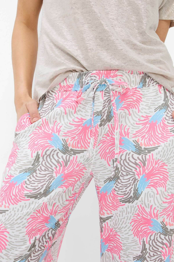 Pantalon imprimé MAINE avec motif tropical en rose, bleu et gris, offrant confort et style léger.