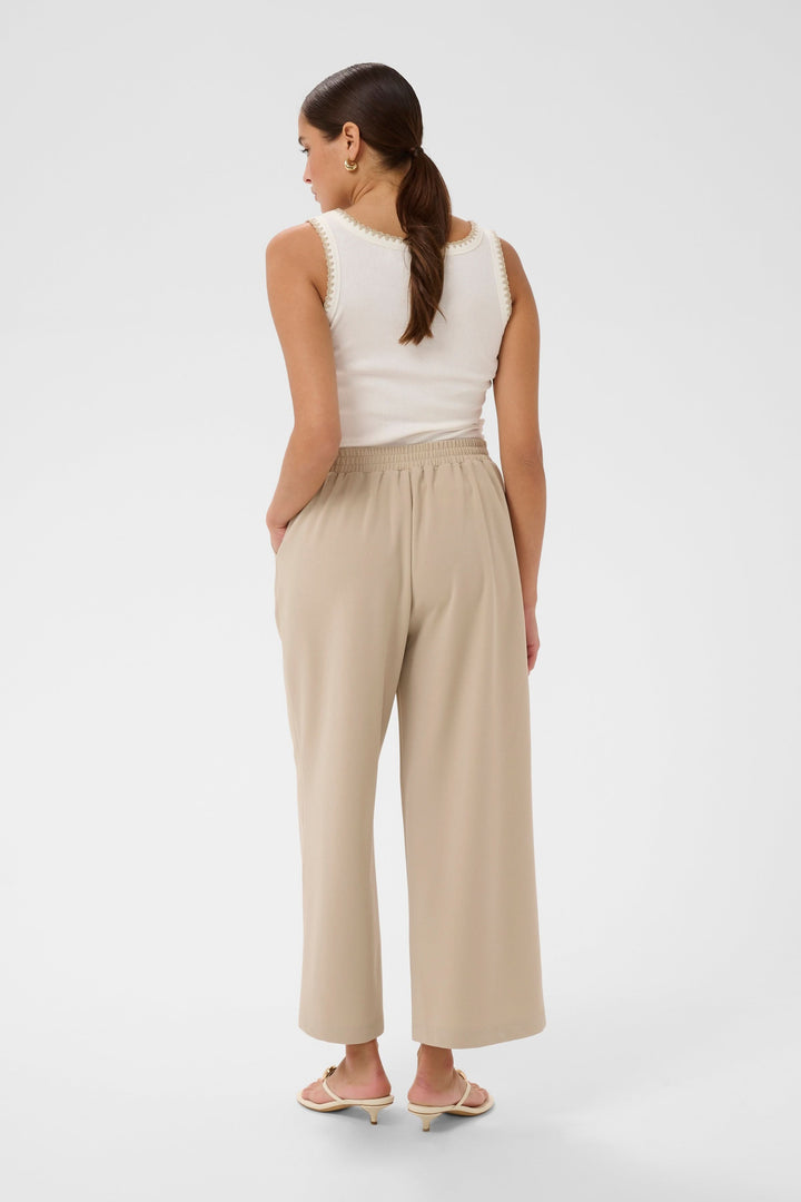 Pantalon jambe large Phoebe beige, vue arrière, coupe fluide et confortable avec taille mi-haute et ceinture intégrée.