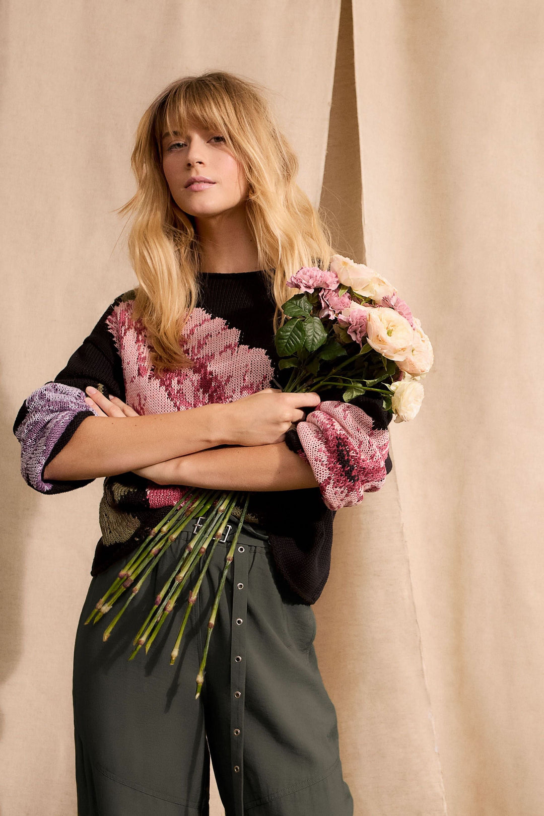 Femme tenant des fleurs portant un pantalon jogger ceinturé tendance.