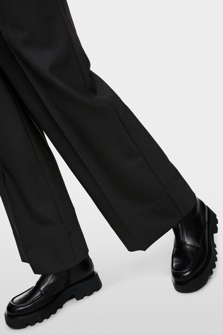 Pantalon large noir pour un style urbain avec chaussures chunky noires, coupe fluide et taille élastique idéale pour le confort et l&