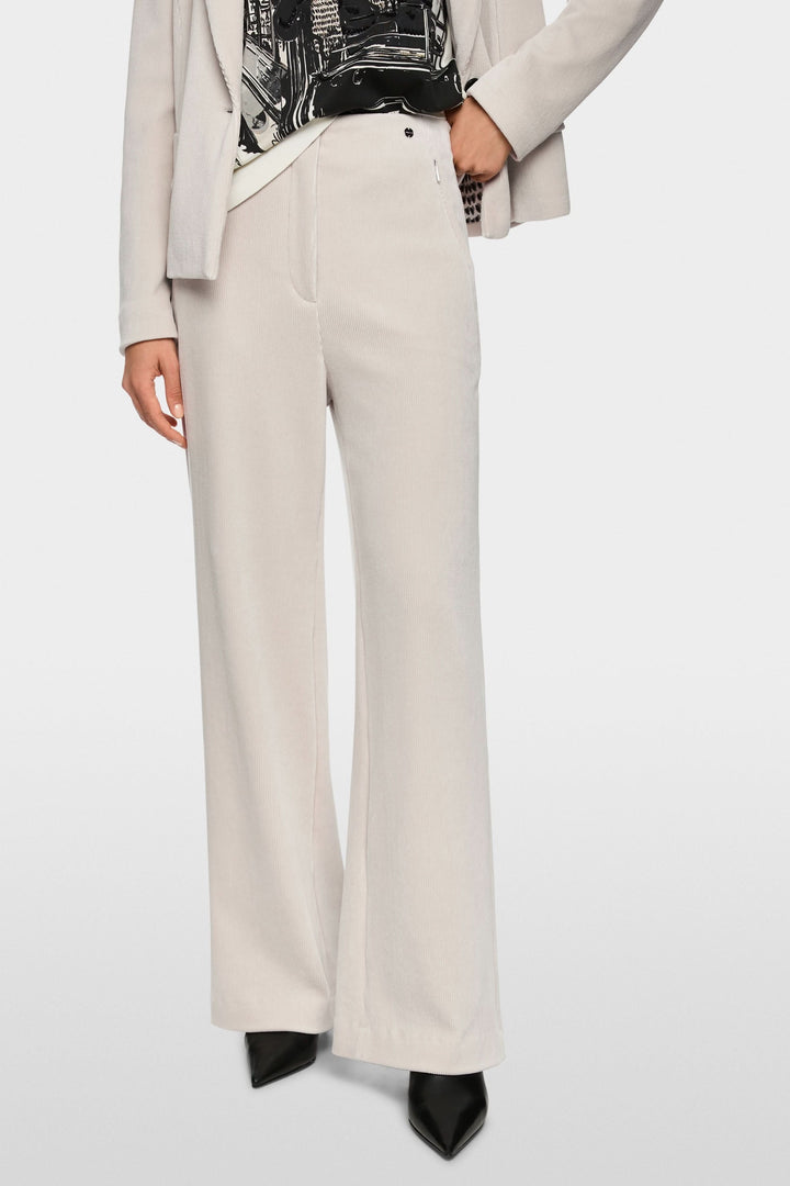 Femme portant un pantalon large en velours côtelé avec blazer, coupe ample et fluide, taille mi-haute, pour un look chic et moderne.