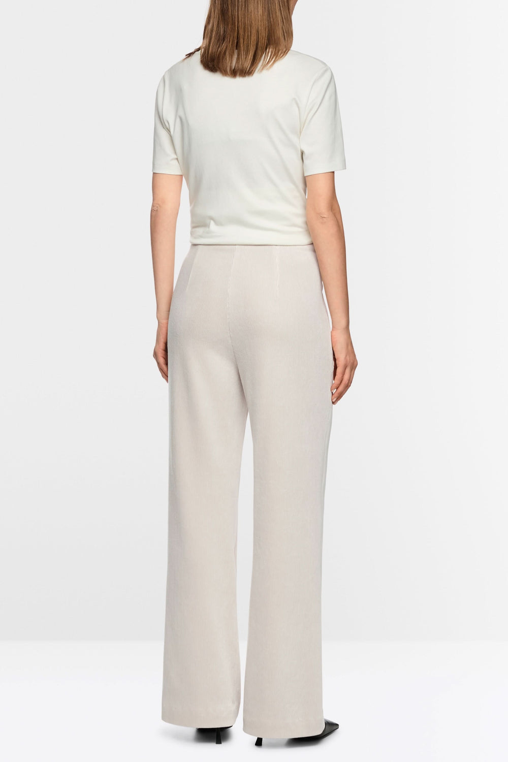 Vue arrière d'un pantalon large en velours côtelé beige porté par une femme, mettant en valeur sa coupe ample et élégante.
