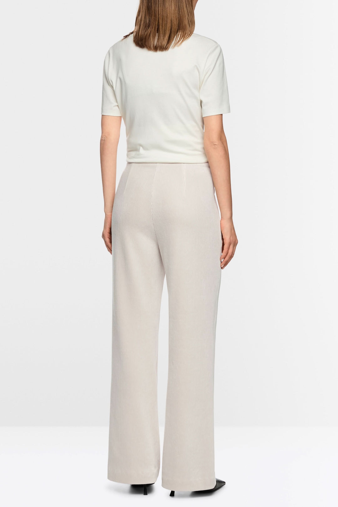 Vue arrière d'un pantalon large en velours côtelé beige porté par une femme, mettant en valeur sa coupe ample et élégante.