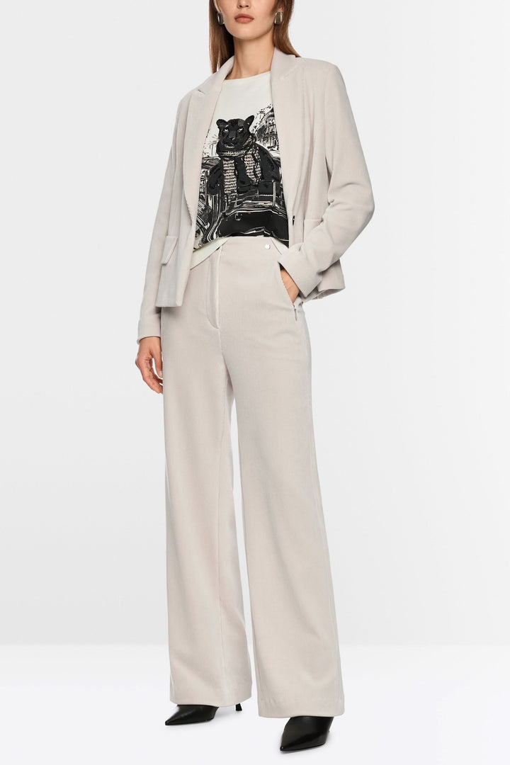 Pantalon large en velours côtelé porté avec un blazer, offrant une silhouette raffinée et moderne, idéal pour un look chic ou décontracté.
