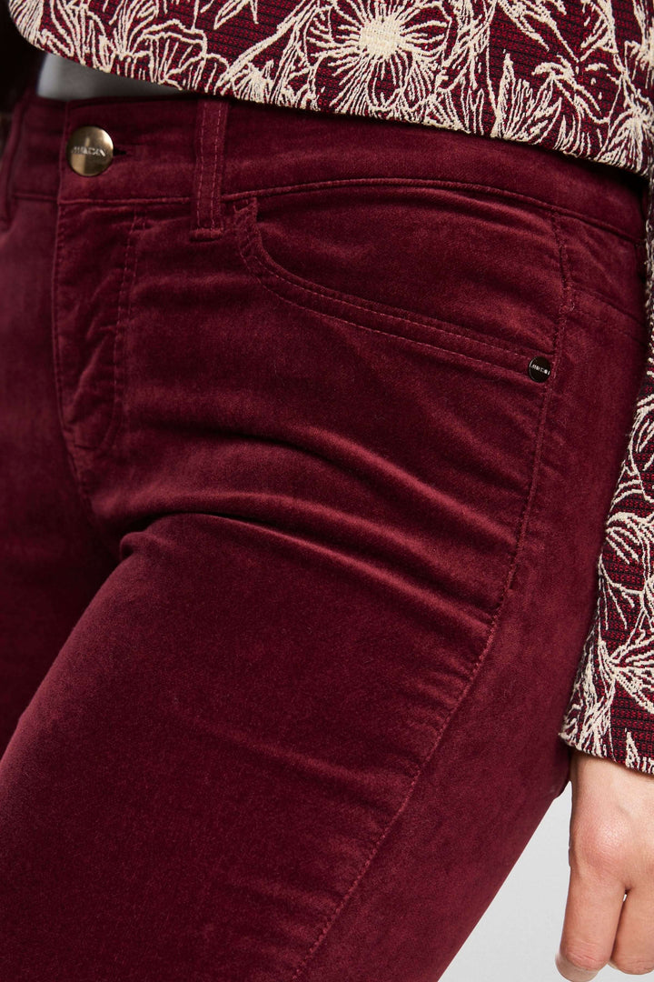 Pantalon taille basse en velours bordeaux avec coupe ajustée et détails élégants, idéal pour un style chic et moderne.
