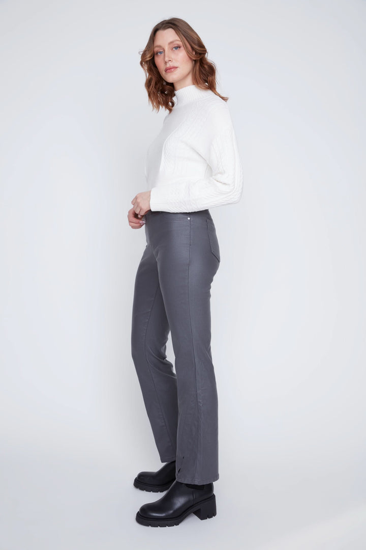 Femme portant pantalon taille haute gris, avec chandail blanc, vue de profil, accent sur la mode chic.