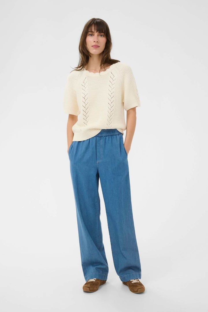 Femme portant le Pantalon taille élastique Aina en denim léger avec coupe droite, idéal pour un look casual et confortable.