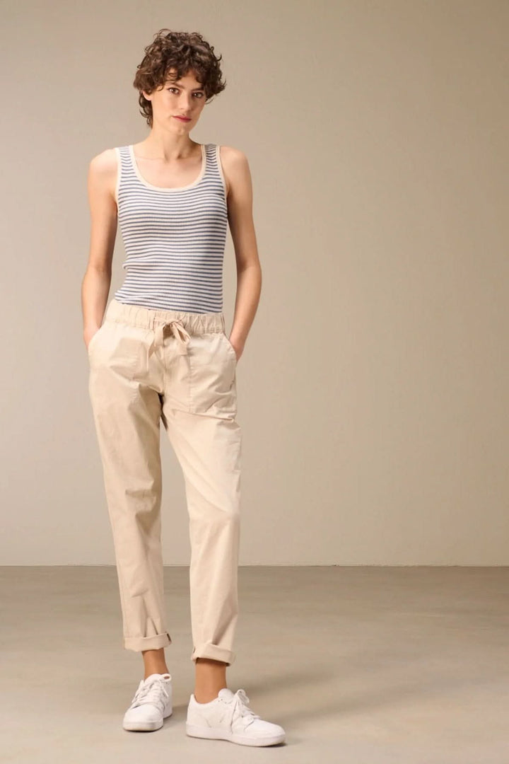 Pantalon taille élastique beige pour femme, silhouette décontractée, avec cordon ajustable, style moderne et confortable.