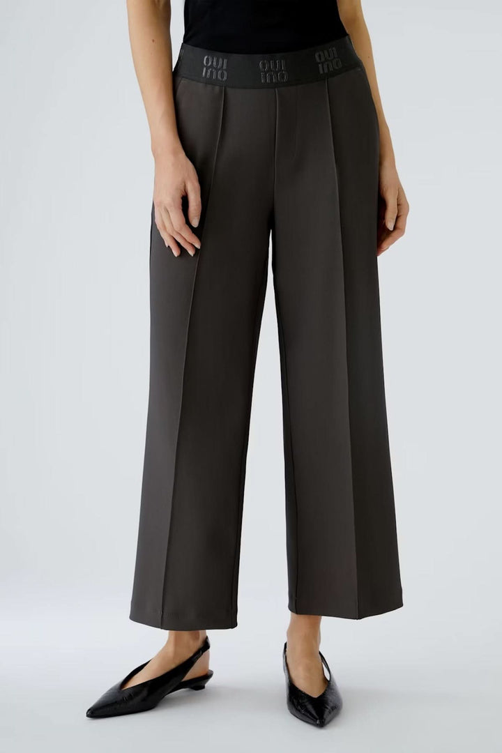 Pantalon ample à taille élastique, fluide avec plis marqués et longueur cheville, idéal pour confort et style moderne. Décris-moi! 