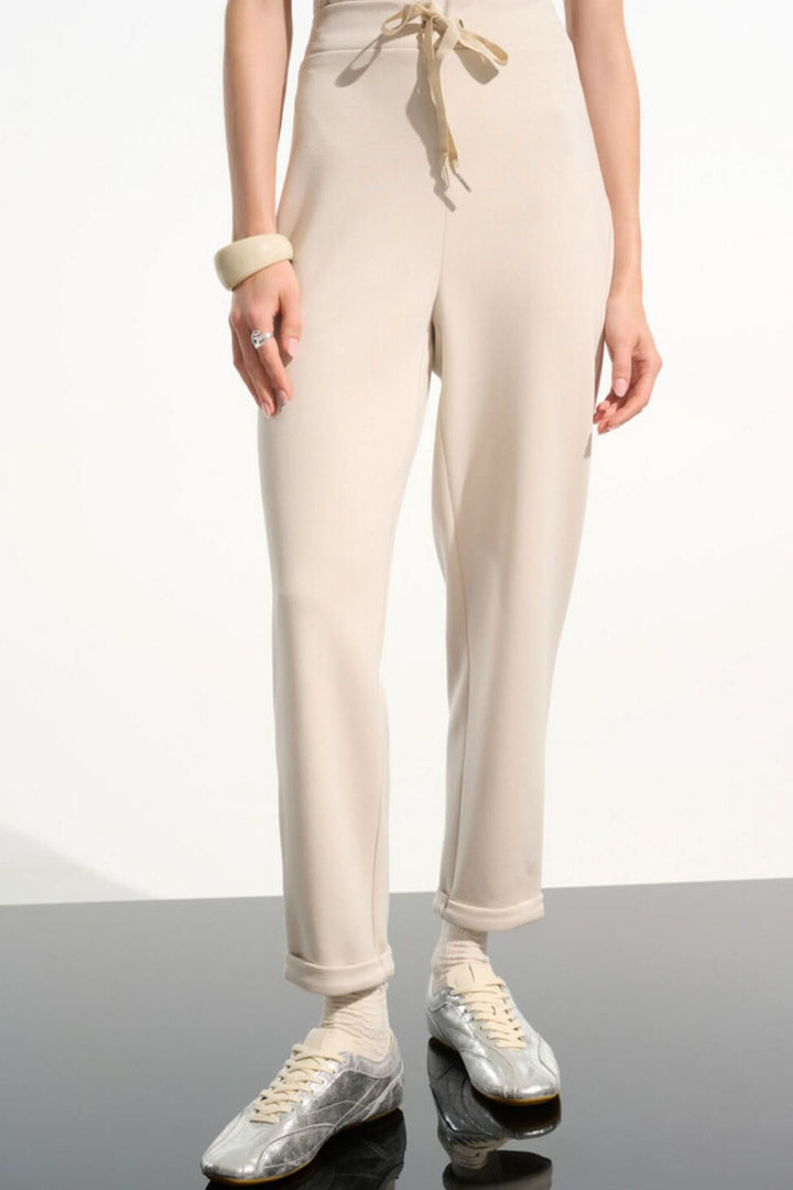 Pantalon à taille nouée coupe droite beige avec taille élastique et cordon, idéal pour une tenue moderne et polyvalente.