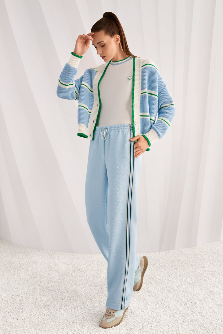 Pantalons à coupe large WASHINGTON avec bandes contrastantes et taille élastique, portant un haut rayé. Mode décontractée et chic.
