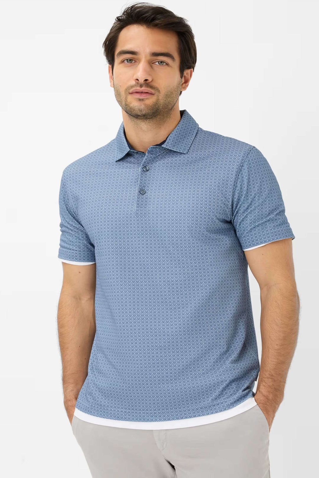 Homme portant un polo à manches courtes à motifs géométriques en bleu, idéal pour un look décontracté chic.