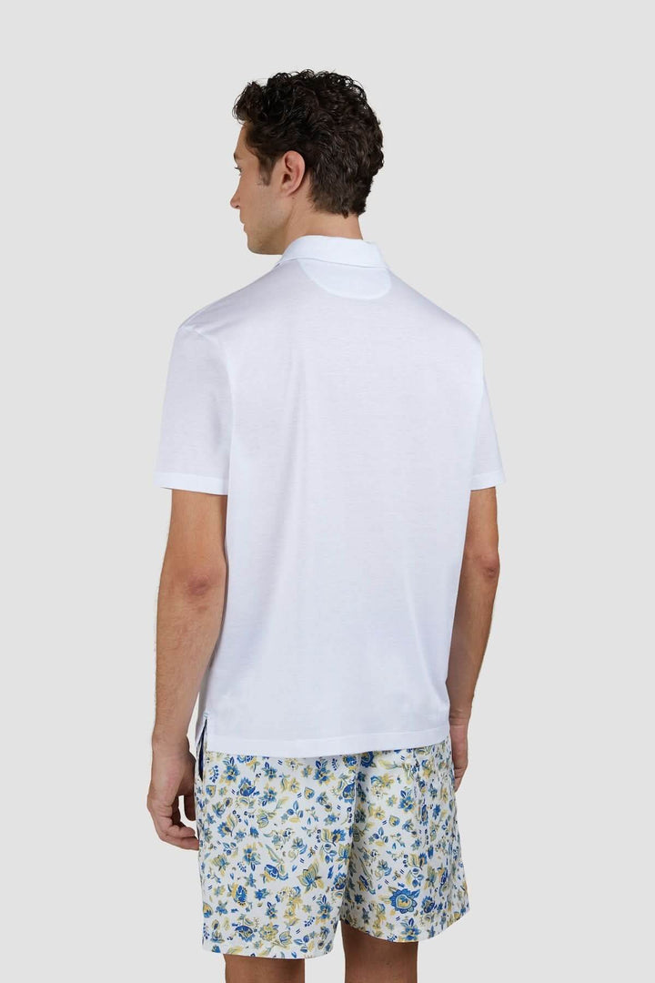 Polo en coton léger avec col contrasté, porté avec un short floral, pour un look estival tendance.