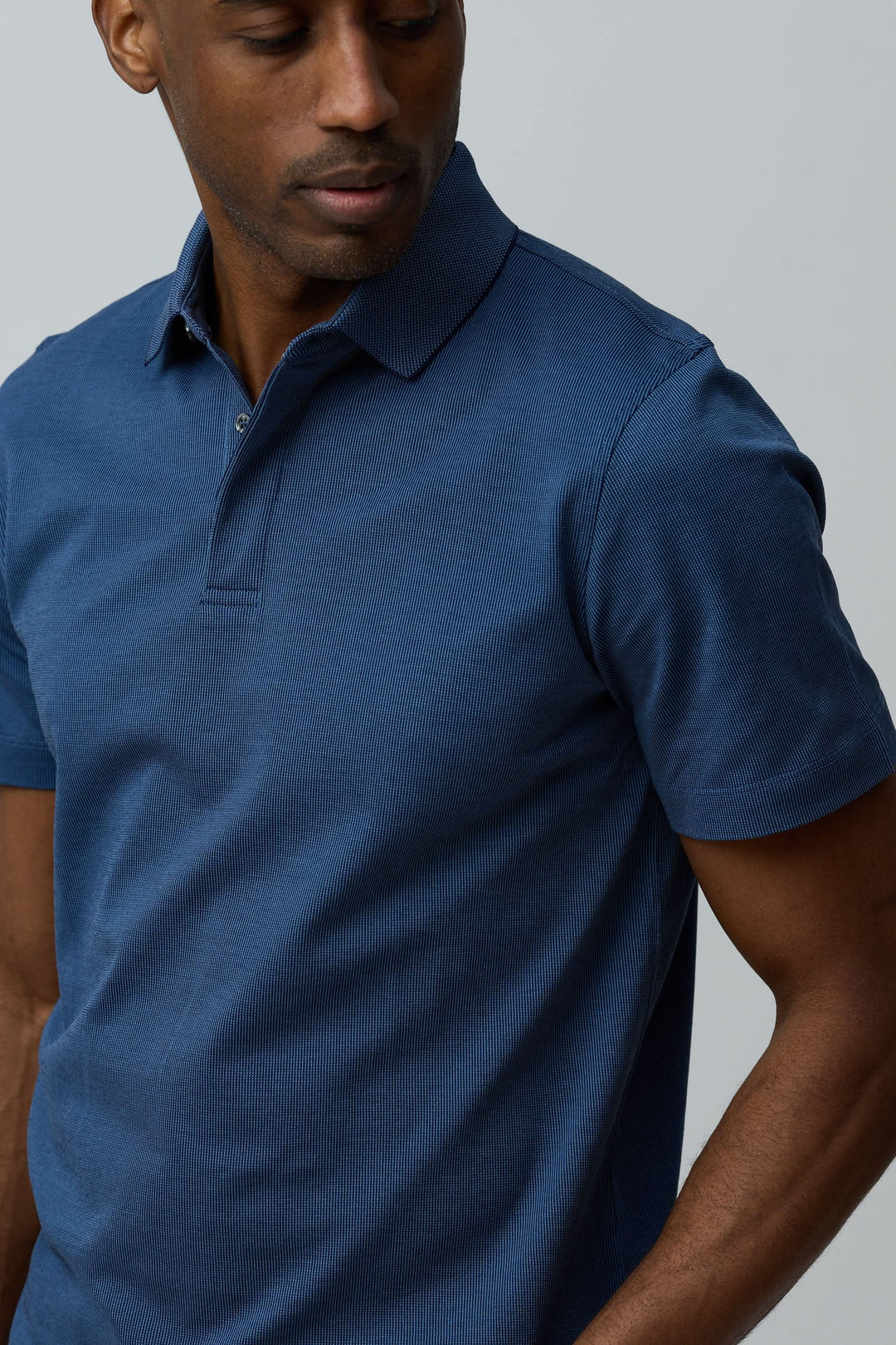 Homme portant un Polo en coton Corneliani bleu à manches courtes avec col classique et maille texturée élégante.