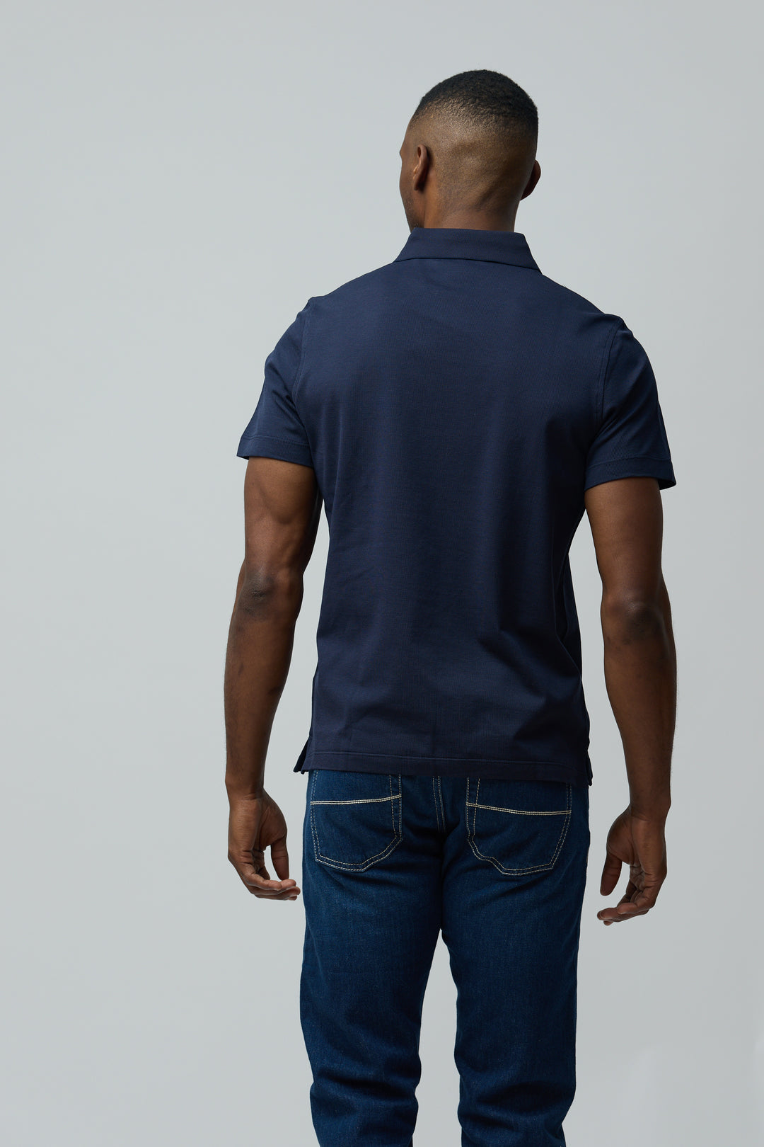 Homme de dos portant un Polo en coton Corneliani bleu avec coupe ajustée, col polo classique et manches courtes.
