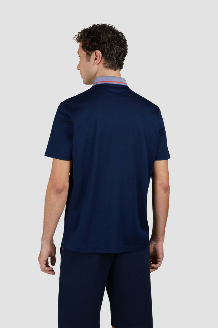 Homme vu de dos portant un polo en coton bleu marine avec col contrastant et fermeture éclair.