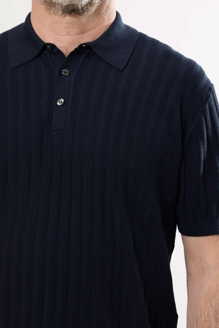 Polo en tricot structuré avec motif côtelé vertical et col classique, idéal pour un style raffiné.