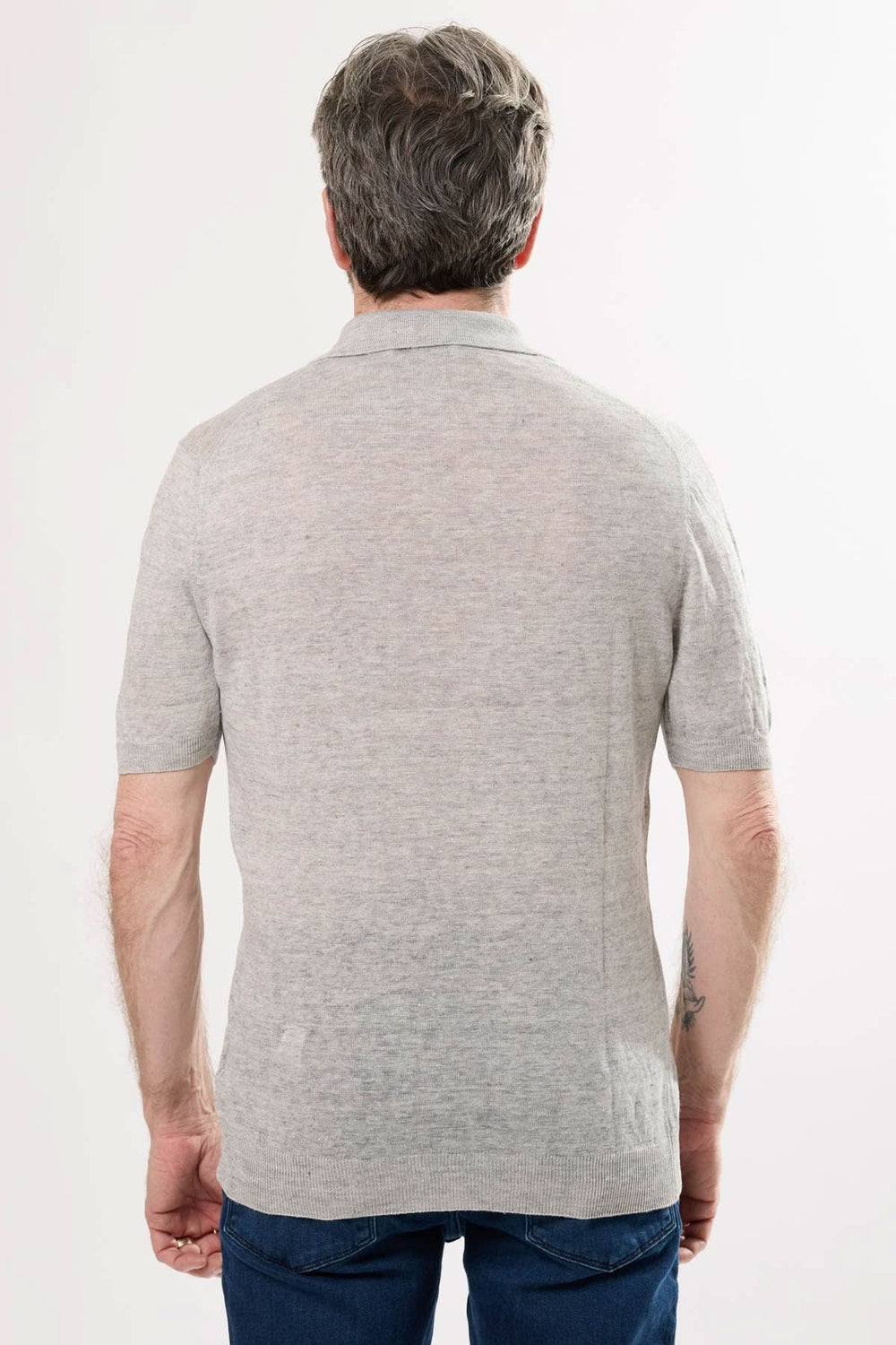 Polo raffiné gris vue arrière, maille texturée, col structuré et manches courtes.