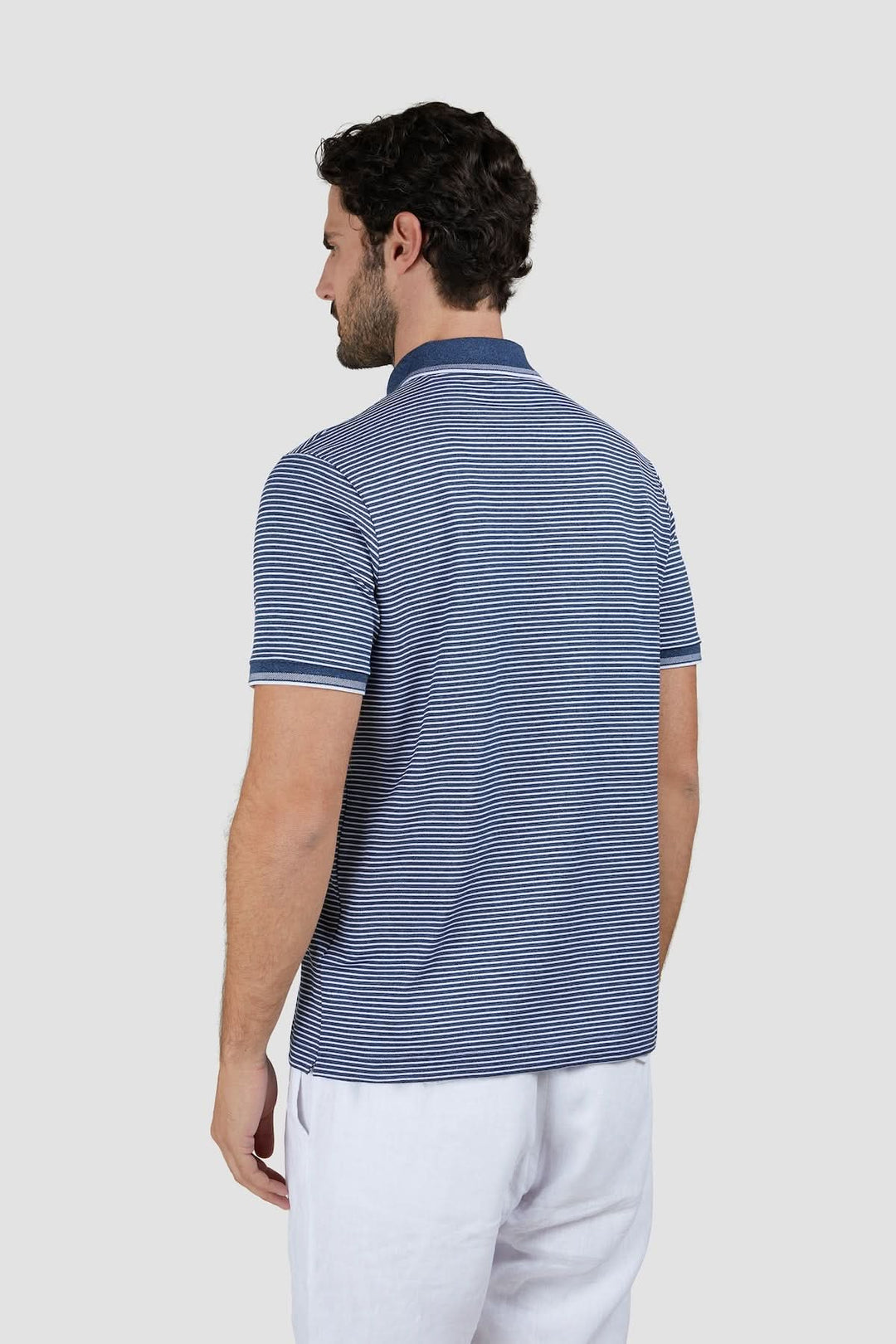 Homme portant un Polo rayé en coton piqué Jaspe, vue de dos, montrant le motif rayé classique et la coupe régulière.