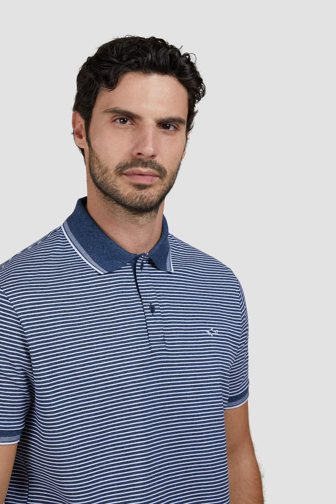 Homme portant un Polo rayé en coton piqué Jaspe avec une broderie discrète.