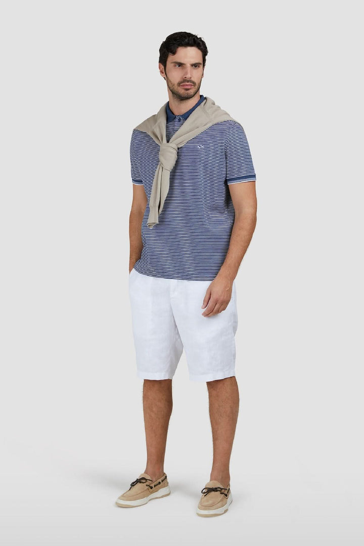 Homme portant un Polo rayé en coton piqué Jaspe avec short blanc, look estival élégant.